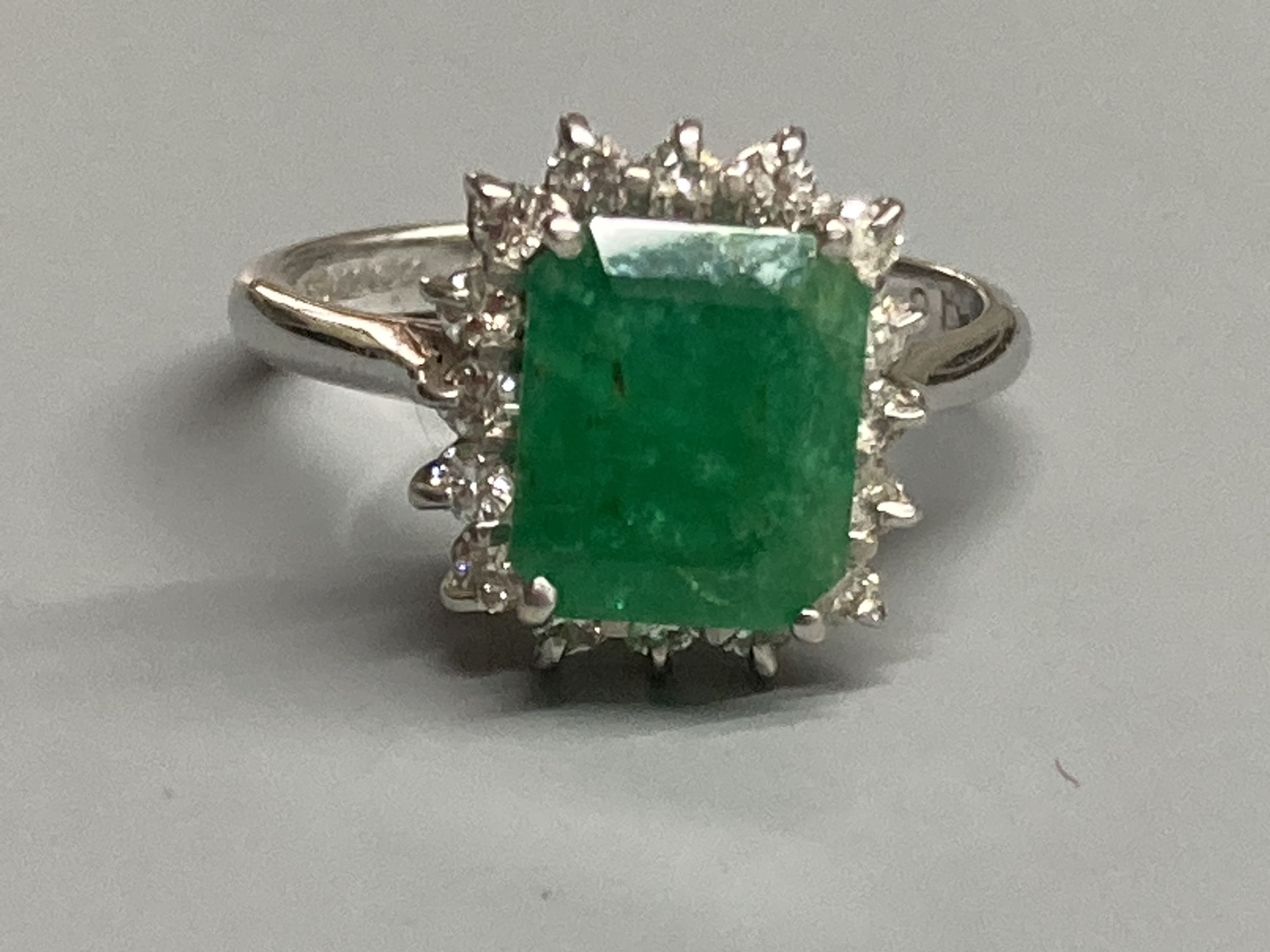 A modern 18ct white gold, emerald and diamond set rectangular cluster ring, size K, gross 3.4 grams.